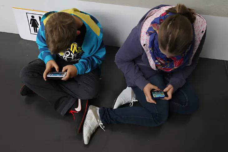 Children on the floor while use their gadget