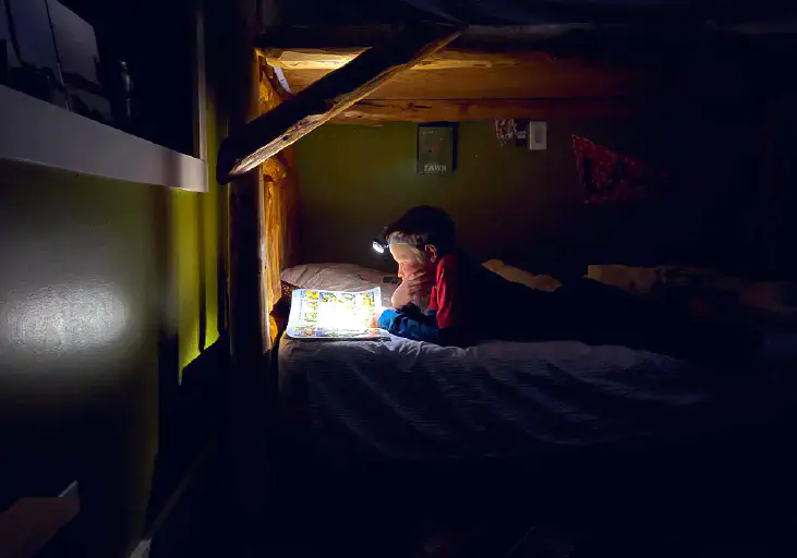 Kids on bed reading a book.