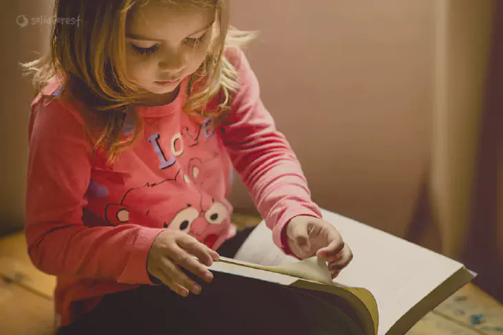 Girl sitting opened a book